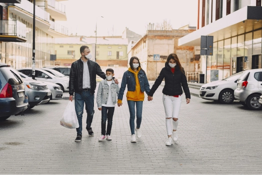 Family wearing mask walking through street