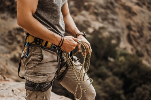 Climber in safety gear with rope, ready for rock climbing.